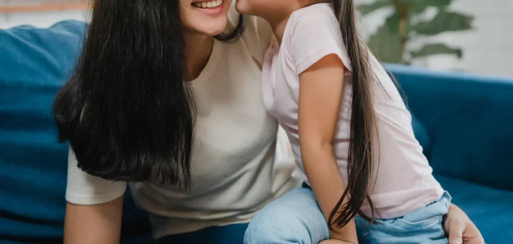 Happy Asian Family Mom Daughter Embracing Kissing Cheek Congratulating With Birthday House 1 Scaled