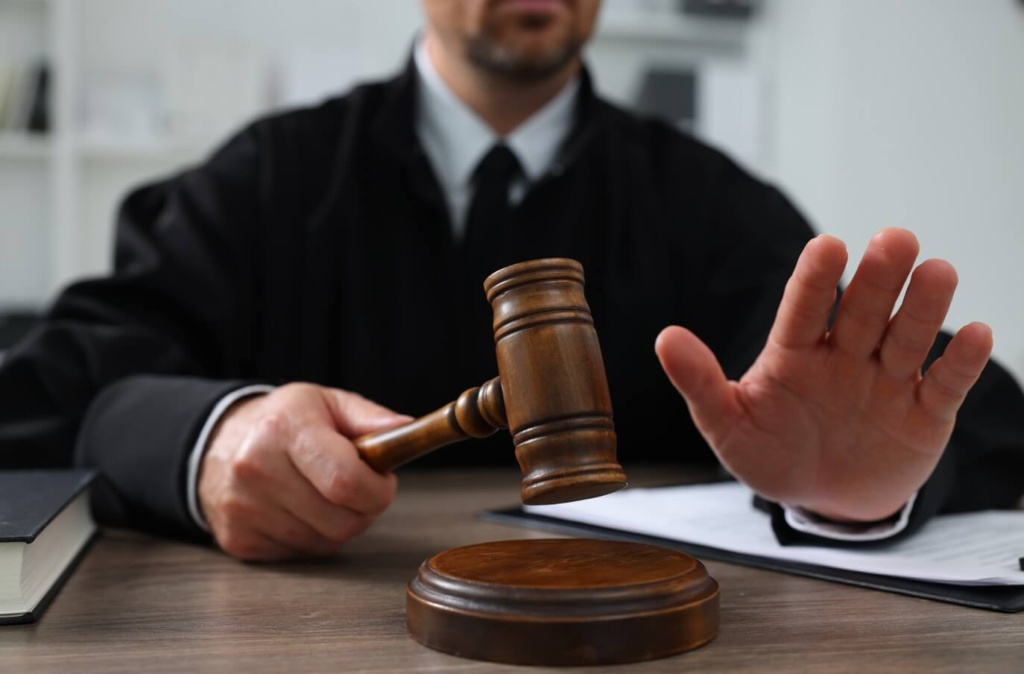Judge Holding A Gavel In A Courtroom, Representing The Court Process For Assault Charges